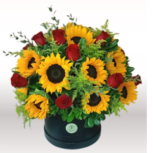 Caja belleza atardecer girasoles, rosas rojas y follajes