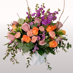 Arreglo Mamá entregada rosas lilas, rosas naranjas y flores mixtas